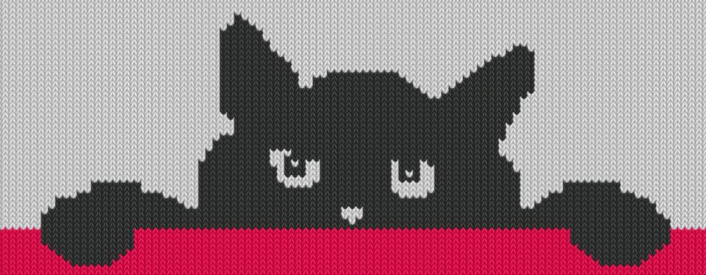 A black cat looking over a red ledge, only its head and one paw showing, knitted on pale grey.